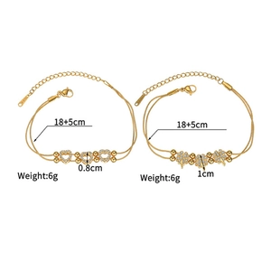 Detailed view of gold stainless steel heart and clover bracelets with zircon charms
