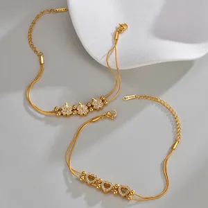 Golden stainless steel bracelets featuring sparkling clover and heart pendants on dual chains