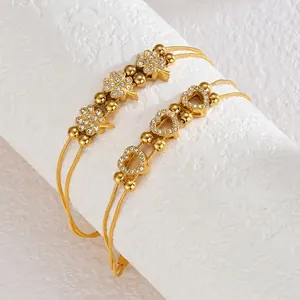 Golden double-layer stainless steel bracelet with clover, heart charms and white rhinestones