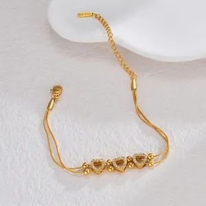Detail of double-layer gold stainless steel heart bracelet with sparkling zircon stones