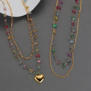 Double-layered golden necklace with colorful crushed stones and heart pendant