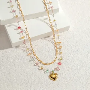 Double-layered gold chain necklace with colorful resin beads and a heart pendant