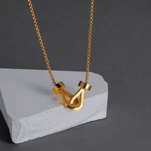 Minimalist double interlocking U-shaped pendant necklace in polished gold finish on stone