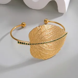 French vintage style gold open bangle with green crystal leaf design and hollow metal details