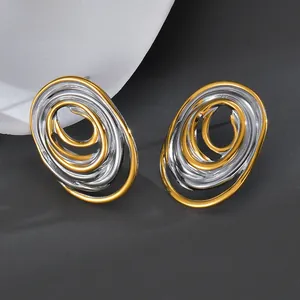 Detail view of irregular geometric layered oval earrings in mixed gold and silver finish