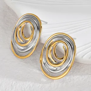 Minimalist geometric oval earrings with two-tone gold and silver interlocking spiral design