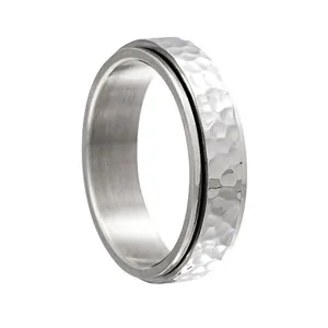 Vue détaillée d'une bague spinner argentée avec une texture martelée et irrégulière
