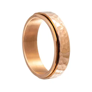 Détail macro d'une bague rotative de 6mm en or rose avec texture martelée irrégulière