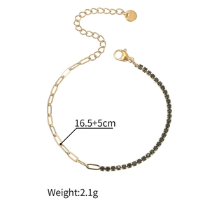 Dettaglio di un bracciale dorato a maglie ovali con zirconi neri e chiusura a moschettone