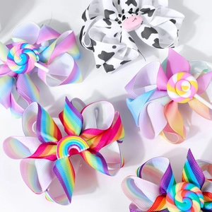 Detail von bunten Regenbogen-Haarspangen mit Lollipop- und Kuh-Dekor aus Ripsband