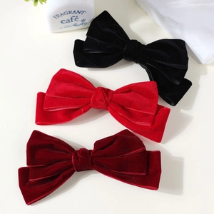 Three large velvet bow hair clips in black, red, and burgundy for elegant styling