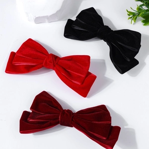 Close-up of three-layered velvet hair bows in red, black and burgundy with satin edges
