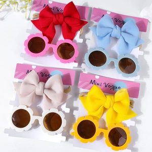 Détail de bandeau bébé avec nœud et lunettes de soleil fleurs sur cartes blanches