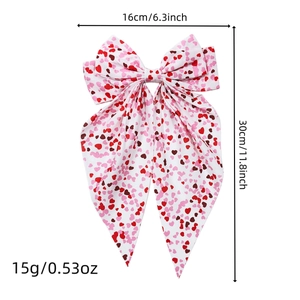 Oversized white hair bow clip with red heart prints and long ribbons for Valentine's Day