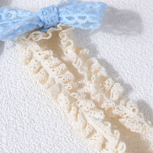 Vue macro de la texture de nœud en dentelle délicate en bleu clair et blanc crème