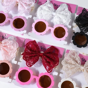 Vue détaillée d'un ensemble bandeau à nœud en dentelle et lunettes fleur bébé