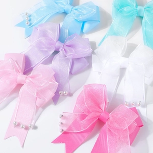 Primer plano de horquillas de doble lazo de organza y encaje con perlas elegantes