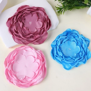 Macro detail of multi-layered 10cm fabric flowers in burgundy, light blue, and pink