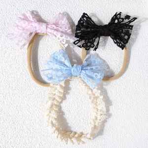 Détail de bandeaux pour bébé avec nœuds en dentelle rose, noir et bleu clair