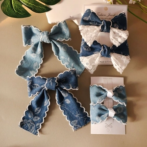 Detailansicht von Jeans-Schleifen-Haarspangen mit Blumenmuster und gewellter Spitze