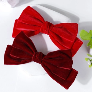 Detailed macro view of high-quality velvet bow hair clips in vibrant red and burgundy colors