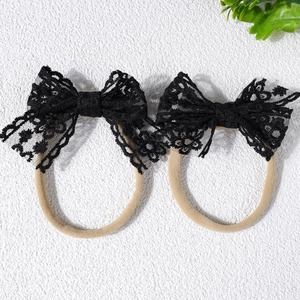 Gros plan de bandeaux bébé avec nœuds en dentelle noire et bandes en nylon souple