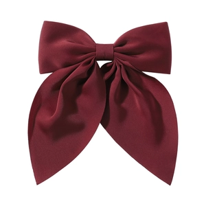 Détail d'une grande barrette à nœud en satin bordeaux avec ruban élégant à double couche