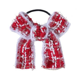 Vue macro d'un chouchou noeud en tricot rouge et blanc avec fils métalliques