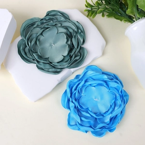 Detailed close-up of 10cm handmade multilayer fabric flowers in dark green and azure blue