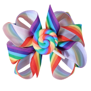 Detail einer Regenbogen-Schleife-Haarspange mit bunter Lollipop-Verzierung aus Harz