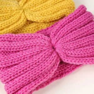 Detailed close-up of ribbed knit texture on pink and yellow cross-knot elastic headbands