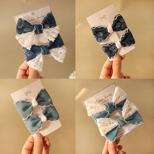 Detail von blauen Denim- und weißen Spitzen-Haarspangen auf einer Schmuckkarte