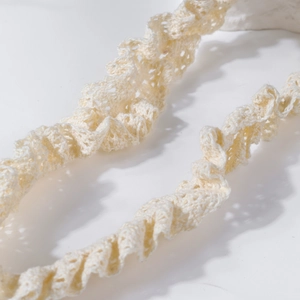 Vue macro détaillée de la délicate texture en dentelle écrue sur le bandeau en nylon pour bébé