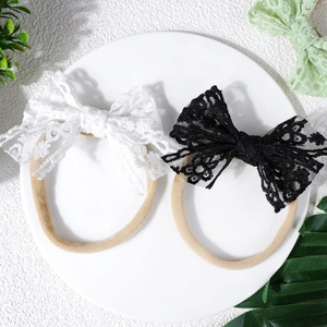 Gros plan de bandeaux bébé en dentelle noire et blanche sur un plateau blanc