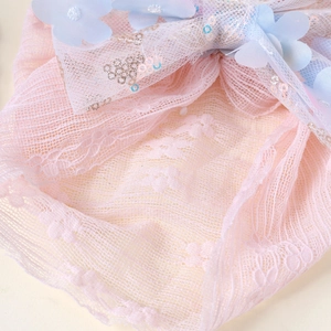 Vue détaillée de dentelle rose superposée avec fleur en résille bleue et paillettes argentées