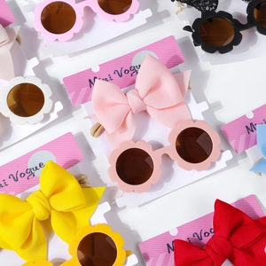 Vue à plat de lunettes de soleil fleurs colorées et bandeaux à nœuds assortis pour bébés