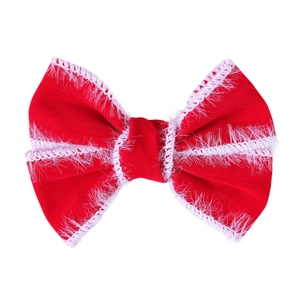 Détail d'un nœud papillon en velours rouge avec bordure en fausse fourrure blanche