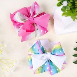 Detailed macro view of gradient rainbow ribbon hair clips with silver heart patterns