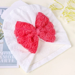 Dettaglio del cappello in pizzo bianco per neonati con grande fiocco di rose rosse 3D