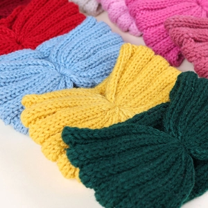 Detail showing various colors of knitted knot headbands with soft ribbed texture
