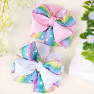 Pink and white rainbow gradient bow hair clips with silver hearts on a clean background