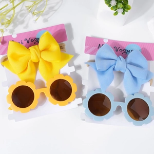 Détail de bandeaux bébé avec nœuds et lunettes de soleil tournesol en emballage jaune et bleu
