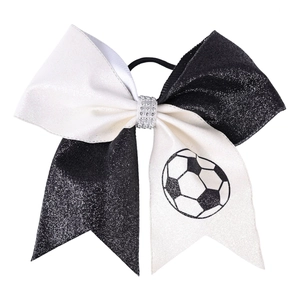 Detail of glitter cheerleader hair bow with football print and rhinestone center