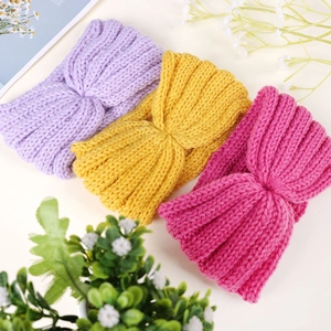 Detailed close-up of chunky knit headbands showing three colors and cross knot pattern