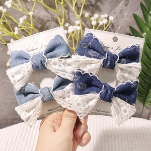 Nahaufnahme der Vintage-Jeans-Haarspange mit weißem Spitzenbesatz auf einer Schmuckkarte