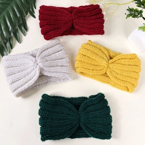 Close-up of four knitted cross-knot headbands in red, grey, yellow, and dark green colors