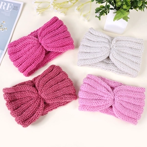 Detailed close-up of knitted twist headbands in four colors for winter warmth
