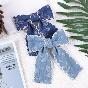 Detail von blauen Denim-Haarspangen mit weißer Spitze und Blumenmustern für Mädchen