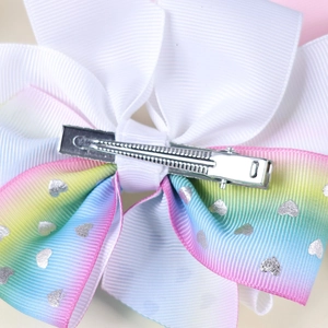 Detail of silver alligator clip back on rainbow gradient ribbon bow hair accessory