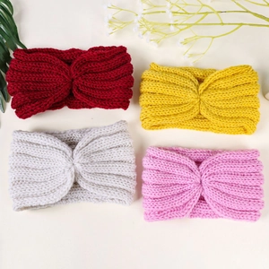 Detailed knit texture of four colorful cross-knot headbands in red, yellow, white, and pink